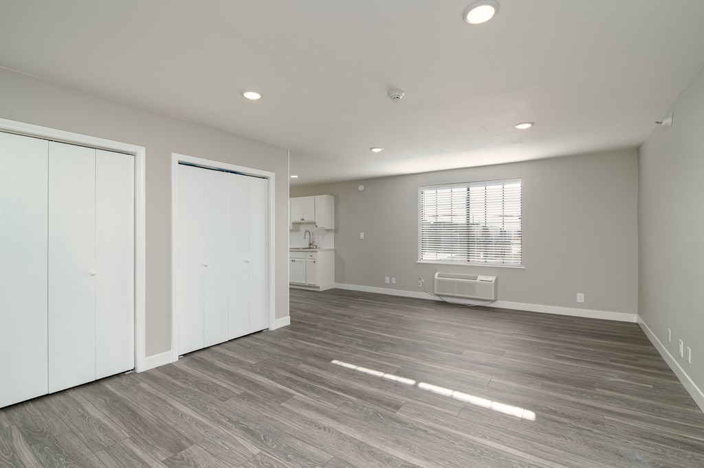 an empty living room with white walls and wood flooring