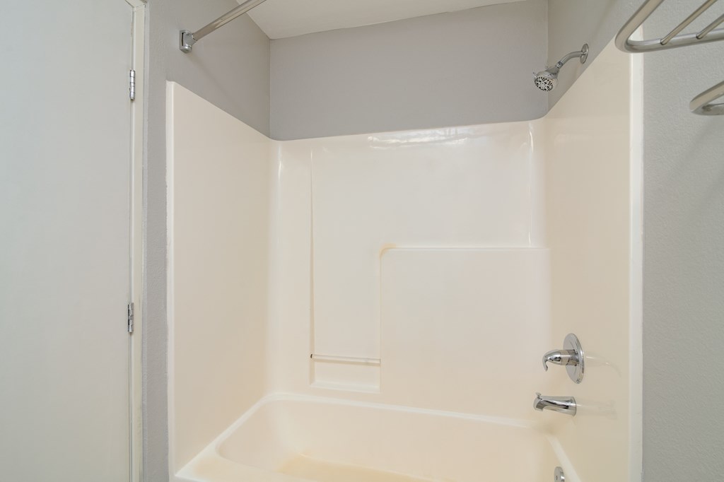 a white bathroom with a shower and a tub