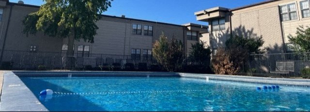 a swimming pool with a building in the background