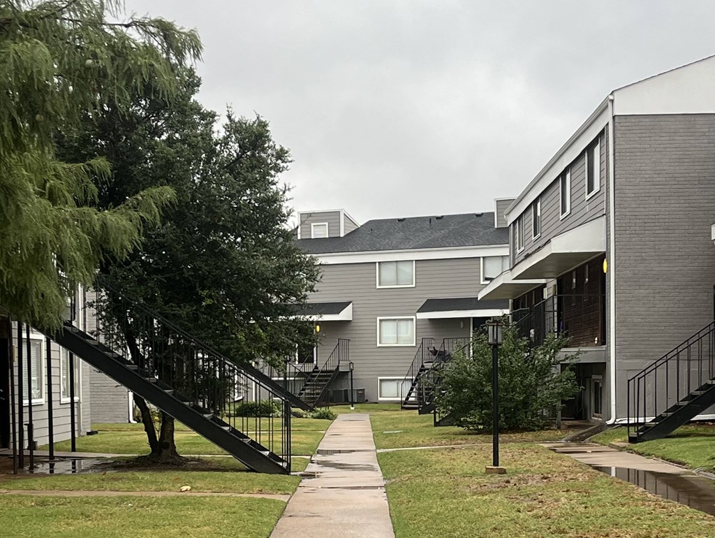 a row of houses with stairs and trees in the yard