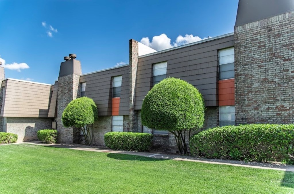 A modern building with a green lawn in front.