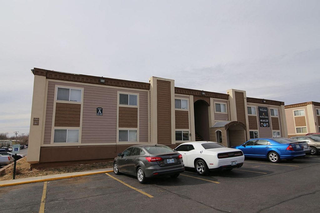 an apartment building with cars parked in front of it