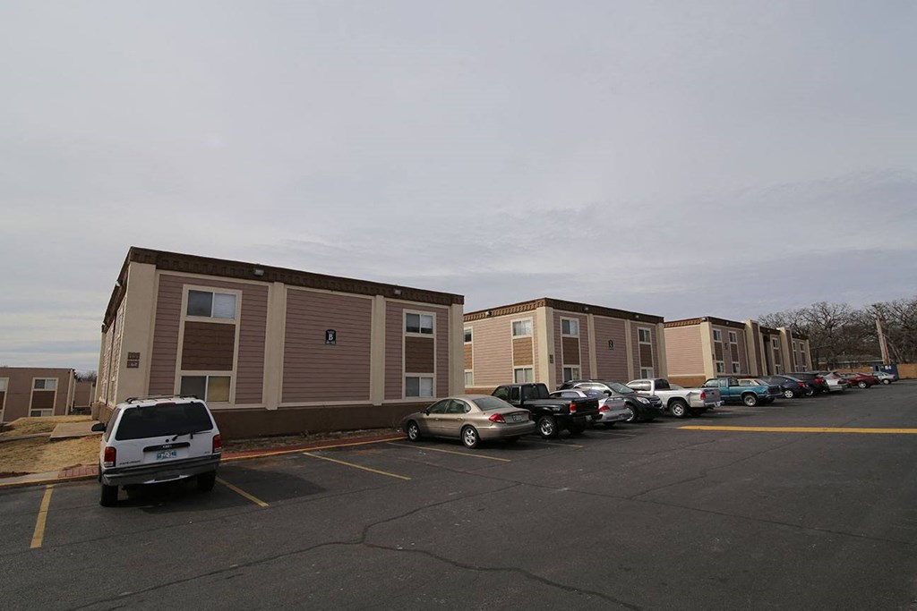a parking lot filled with cars in front of buildings