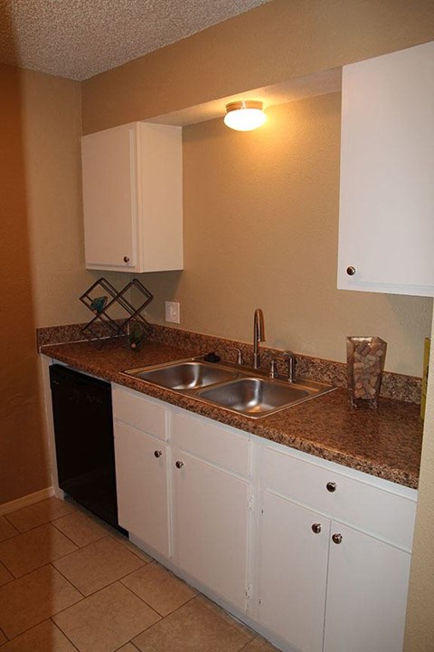 a kitchen with a sink and white cabinets