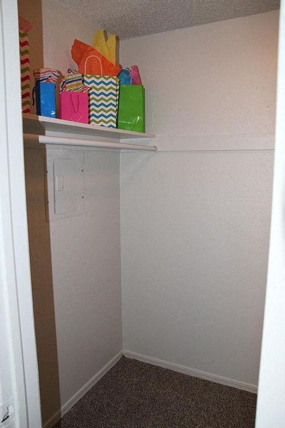 a closet with a shelf with bags on it