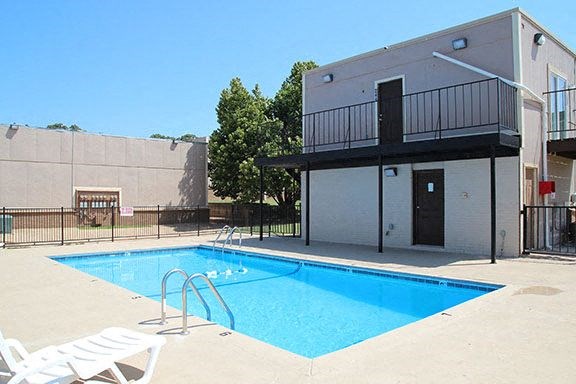 a blue swimming pool in front of a building