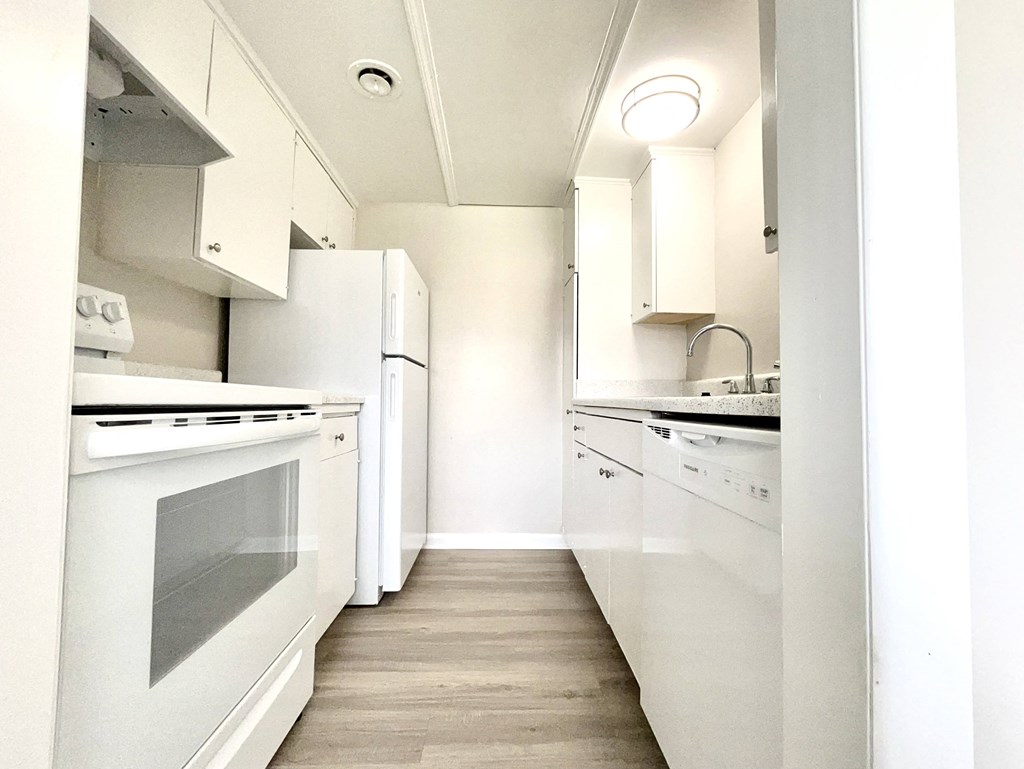a white kitchen with white appliances and white cabinets