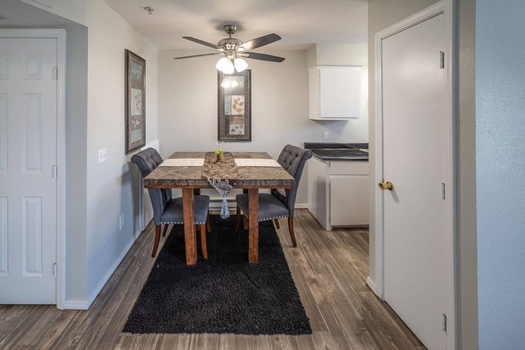 A dining room with a table and chairs.