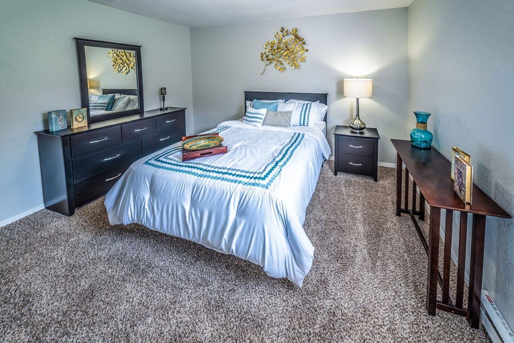 A bedroom with a bed, nightstands, and a lamp.