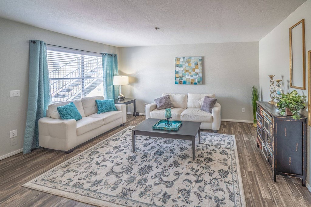 A living room with a white couch, a coffee table, and a rug.
