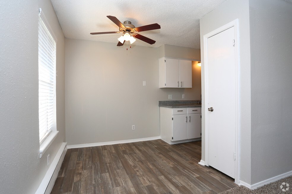 A room with a ceiling fan and wooden flooring.