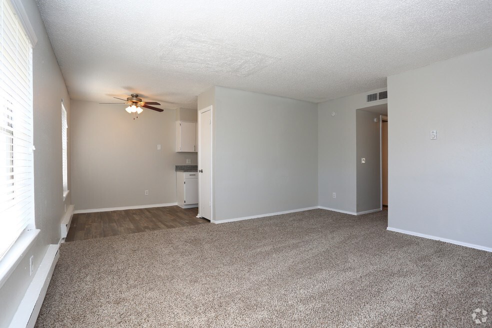 A room with a ceiling fan and carpeted floor.