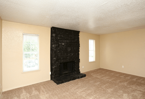 A room with a fireplace and carpeting.
