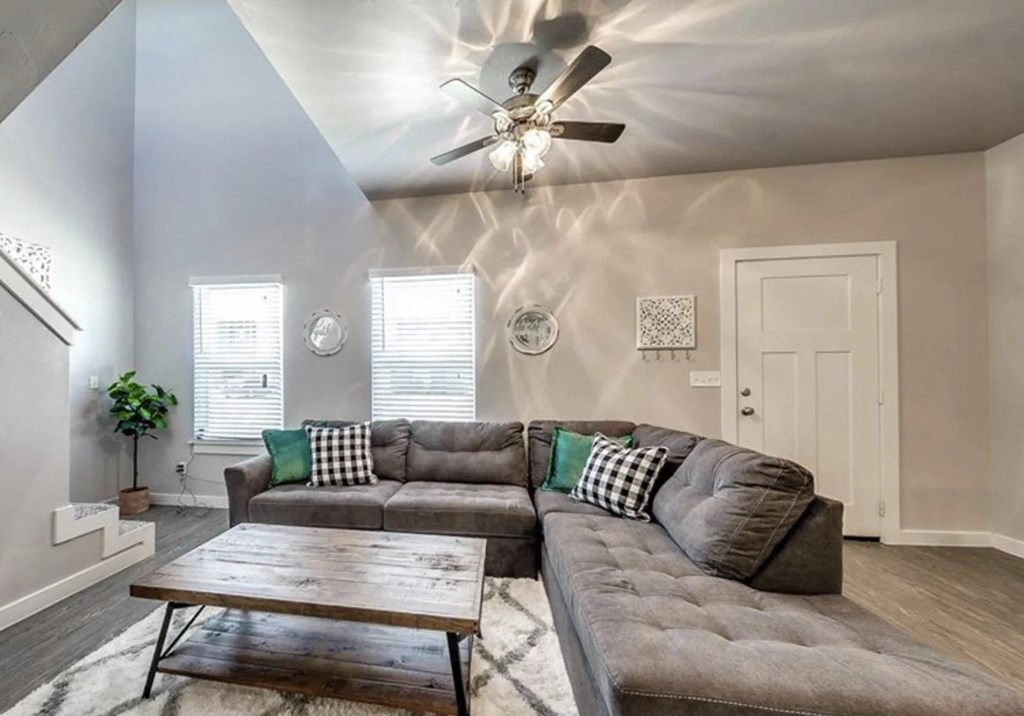 A living room with a grey couch and a wooden coffee table.