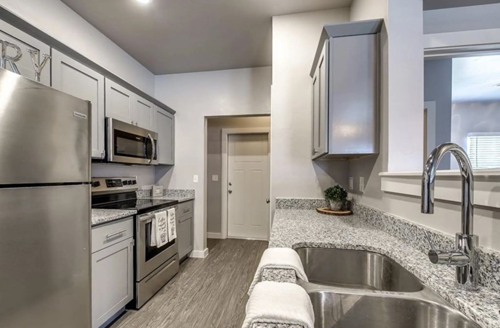 A modern kitchen with stainless steel appliances and a granite countertop.