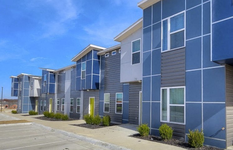 A row of modern townhouses with blue and grey exteriors.
