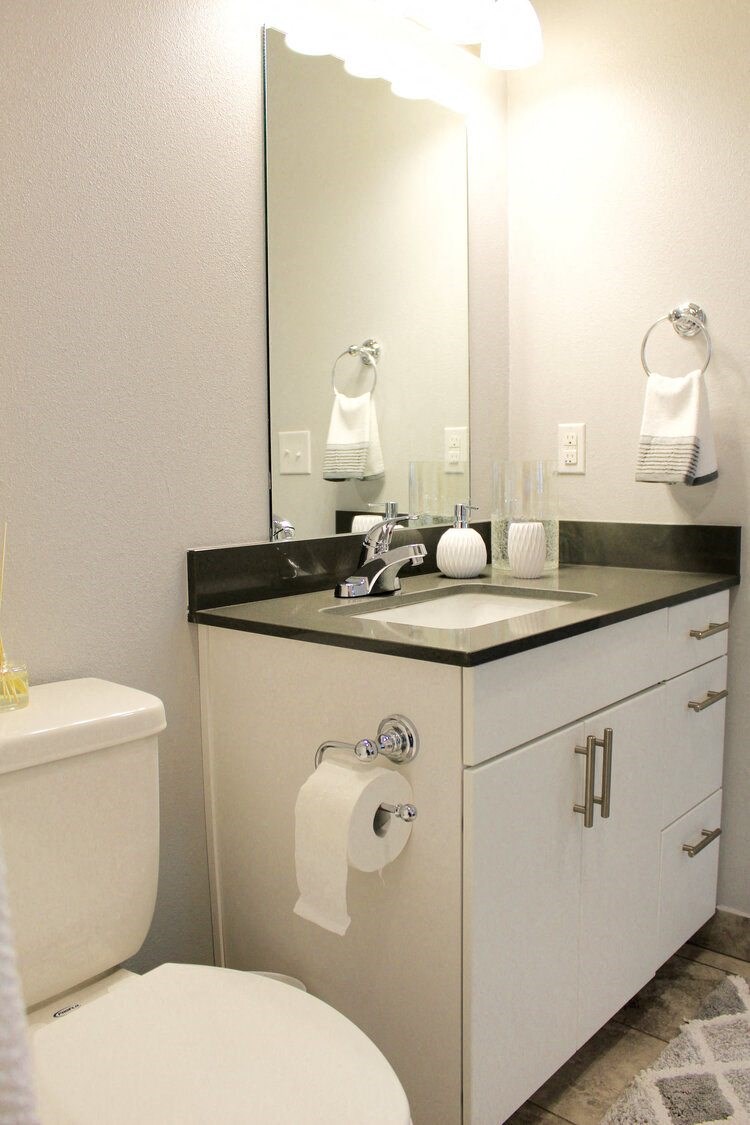 a bathroom with a toilet and a sink and a mirror
