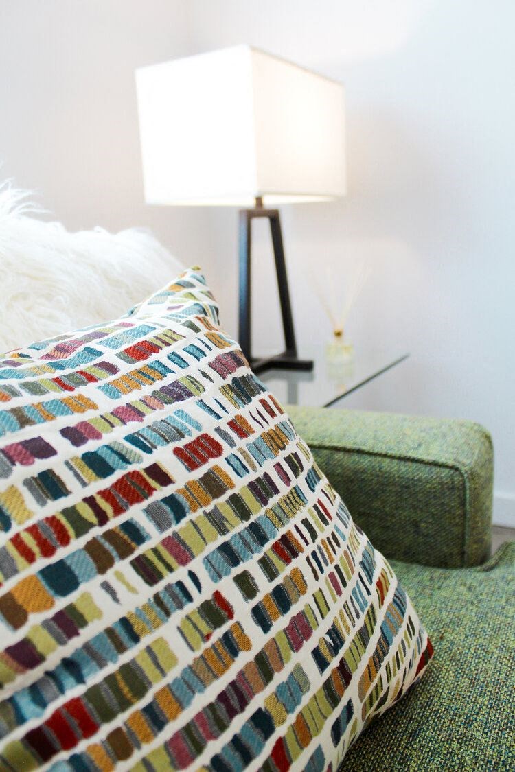 a pillow on a couch in a room with a lamp