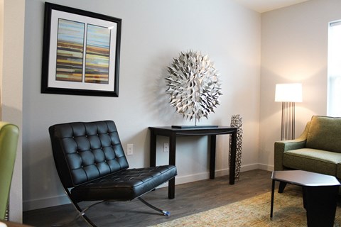 a living room with a black leather chair and a table