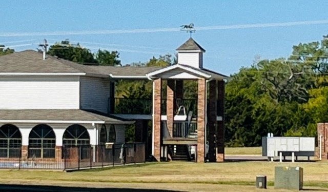 a church with a porch and a building with a tower