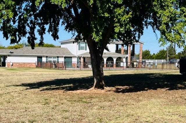 a large tree in a field in front of a house