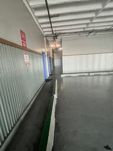 A long corridor with a red sign on the wall.