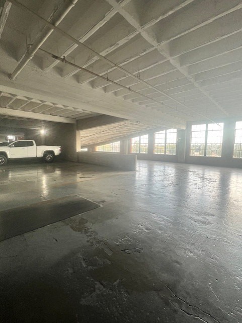 A large, empty parking garage with a white truck parked in the background.