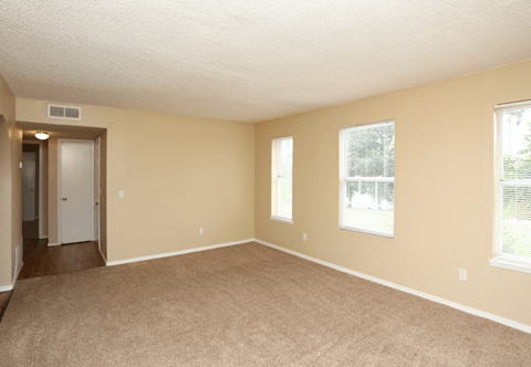 A room with beige walls and carpeted floor.