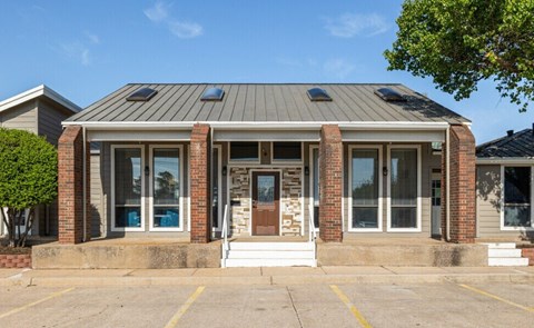 A building with a grey roof and brick pillars.