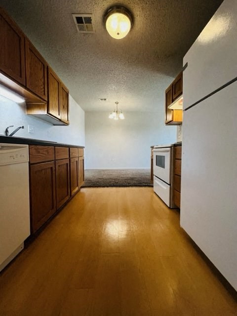 a kitchen with wooden floors and white appliances