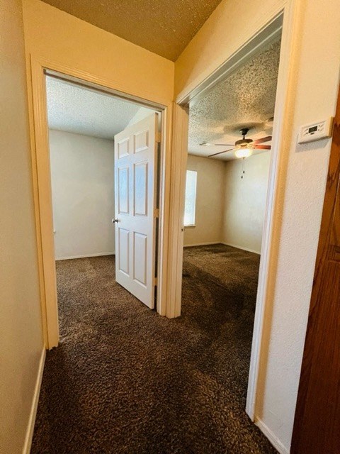 an empty bedroom with a white door and a ceiling fan