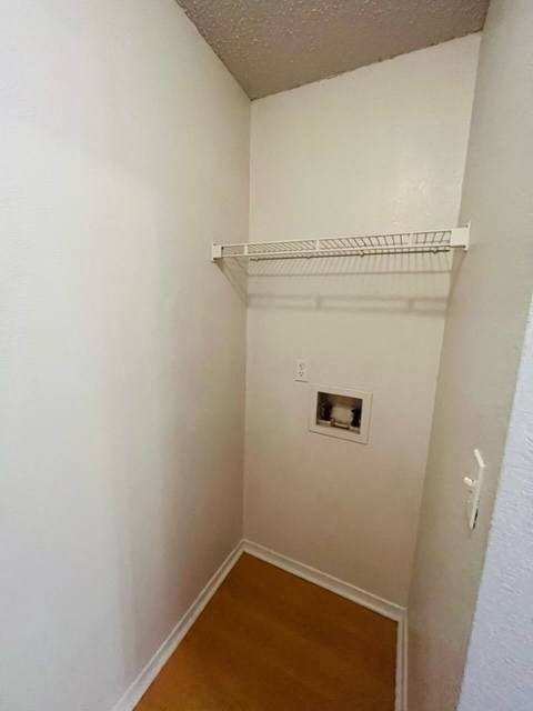 a small room with a white wall and a wood floor