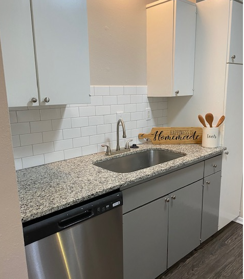 a kitchen with white cabinets and a sink and a counter top