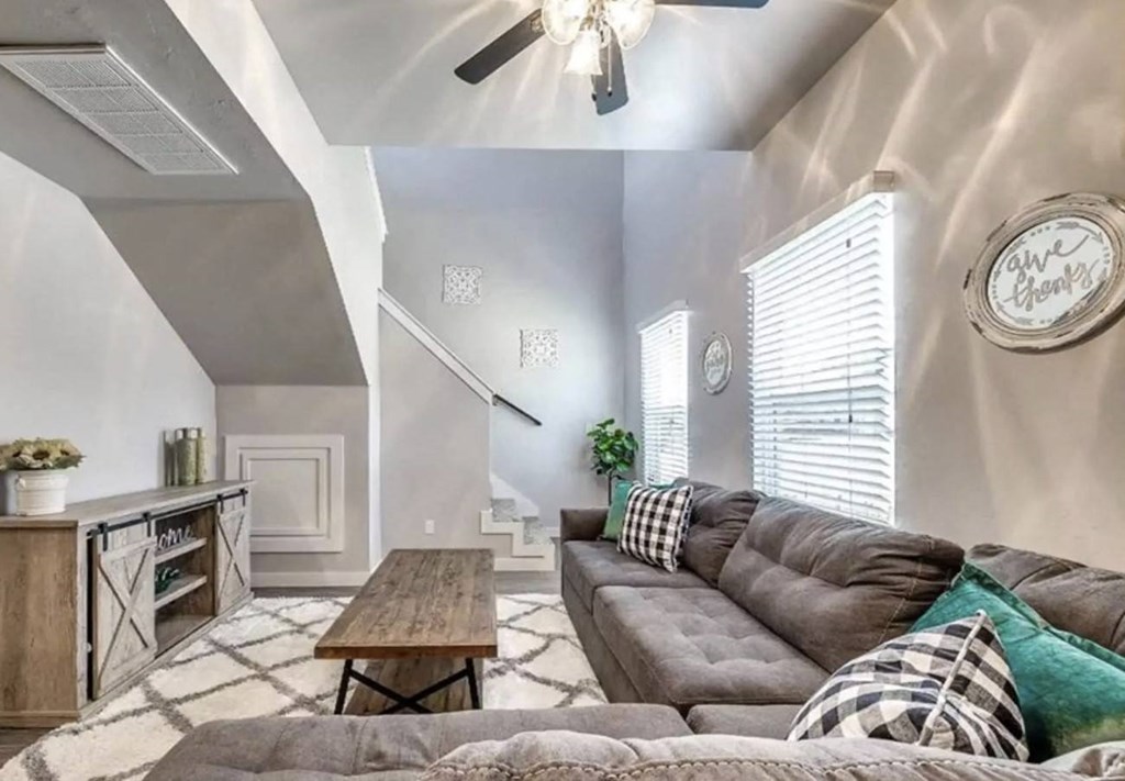 A living room with a grey couch and a wooden coffee table.