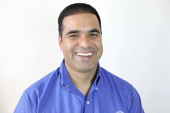 A man in a blue shirt is smiling.