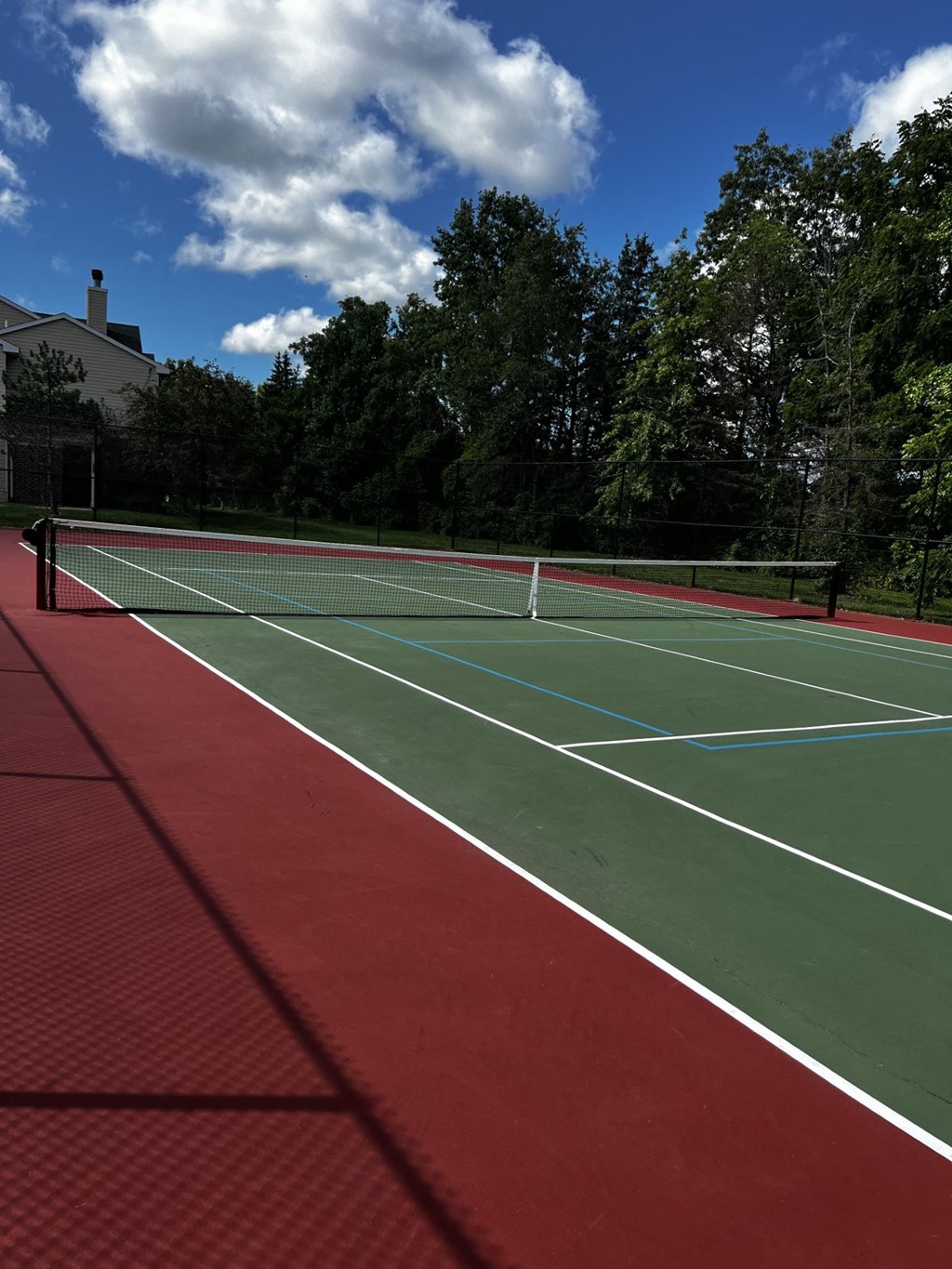 two tennis courts on a red and green court