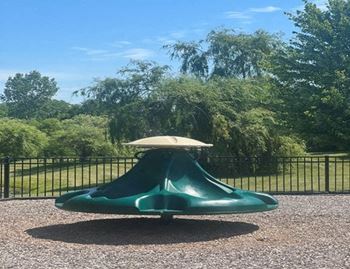 A green slide with a white top in a playground.