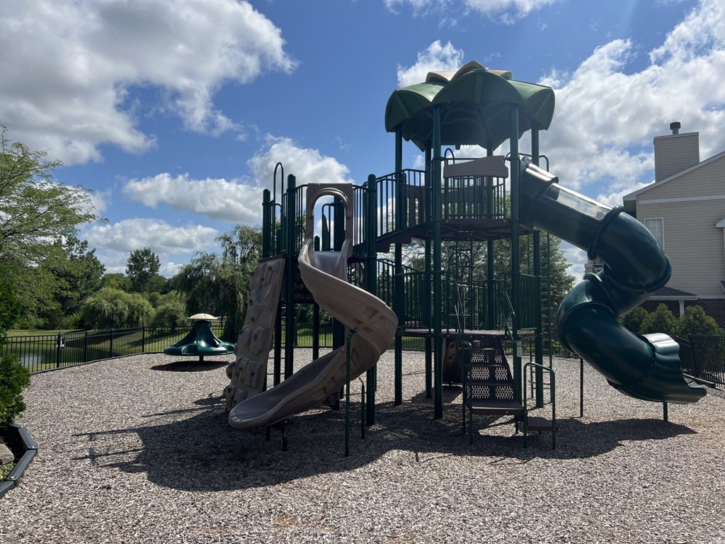 a playground with a slide and climbing equipment in a park