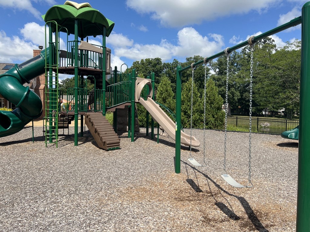 a playground with a slide and climbing equipment in a park