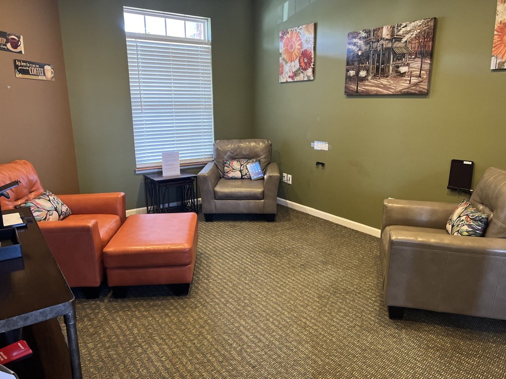 a living room with couches and chairs and a window