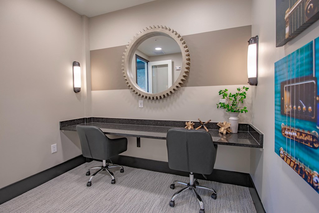 a desk with two chairs in a room with a mirror