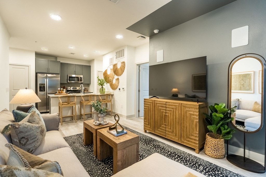 a living room with a couch and a table in front of a kitchen