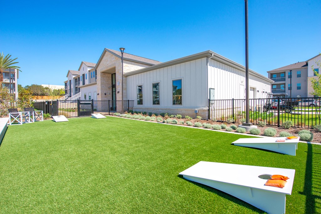 a backyard with a ping pong table and a building