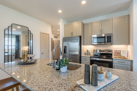 a kitchen with a large island and stainless steel appliances