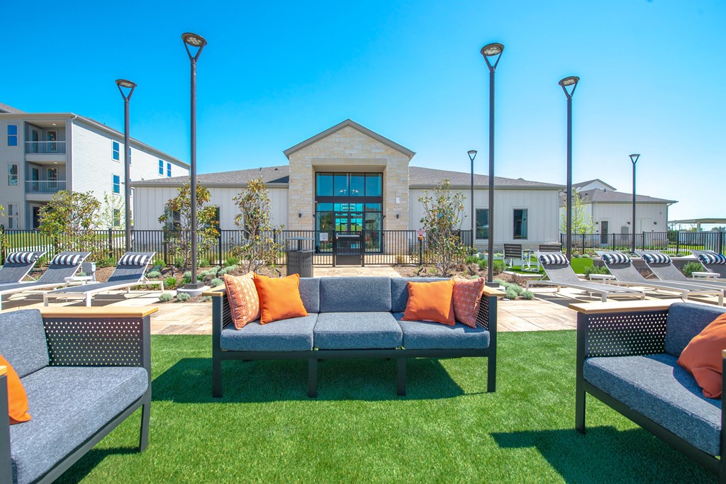 a lounge area with couches and chairs in front of a building