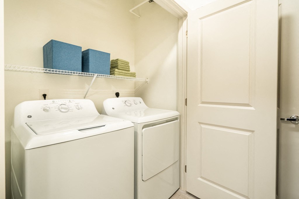 a washer and dryer in a laundry room with a white door