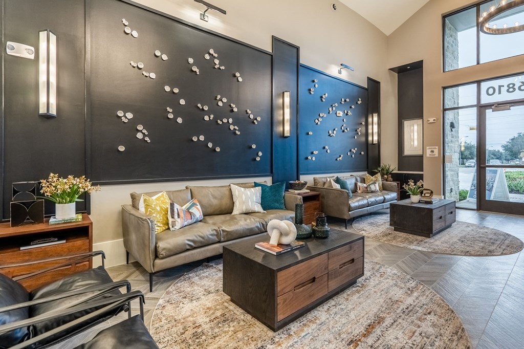 a living room with couches and a large painting on the wall