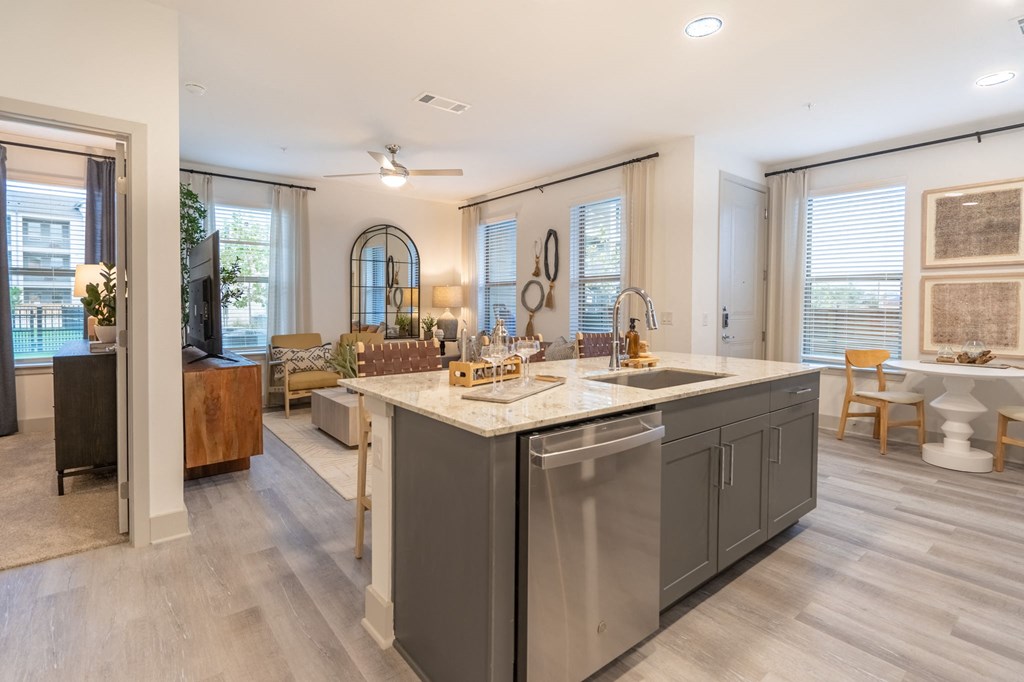 a kitchen with an island and a living room with a couch and a table