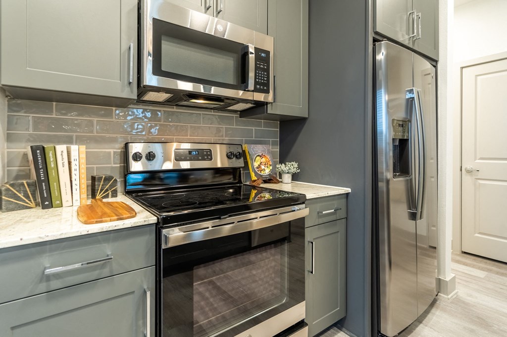 a kitchen with stainless steel appliances and white cabinets