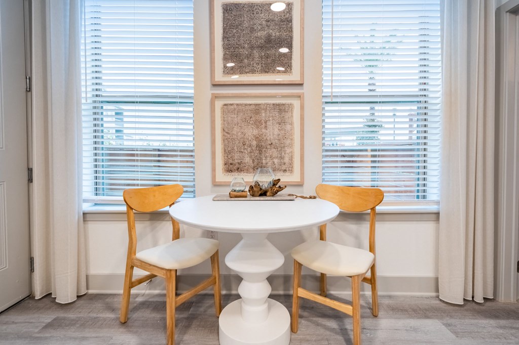 a small dining room with a white table and chairs
